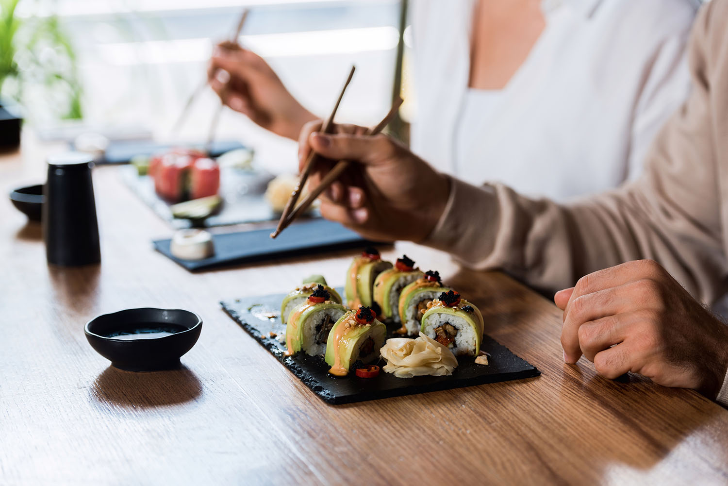 A couple eating sushi at a restaurant.